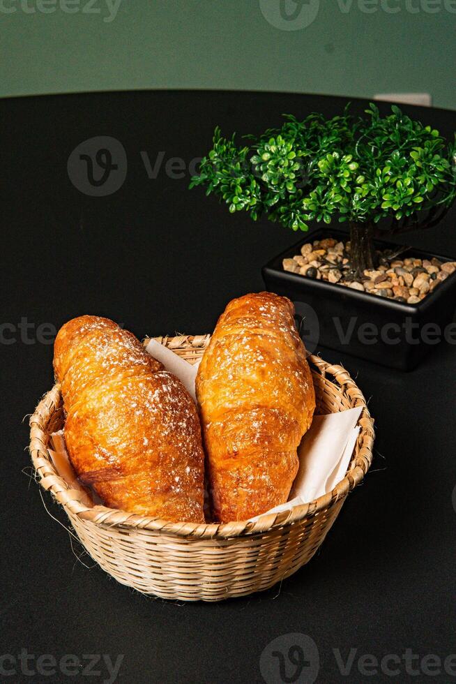 a basket of breads with a plant in the background photo