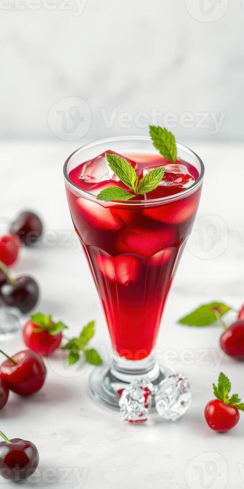 Refreshing cherry drink with mint served in a tall glass surrounded by fresh cherries photo