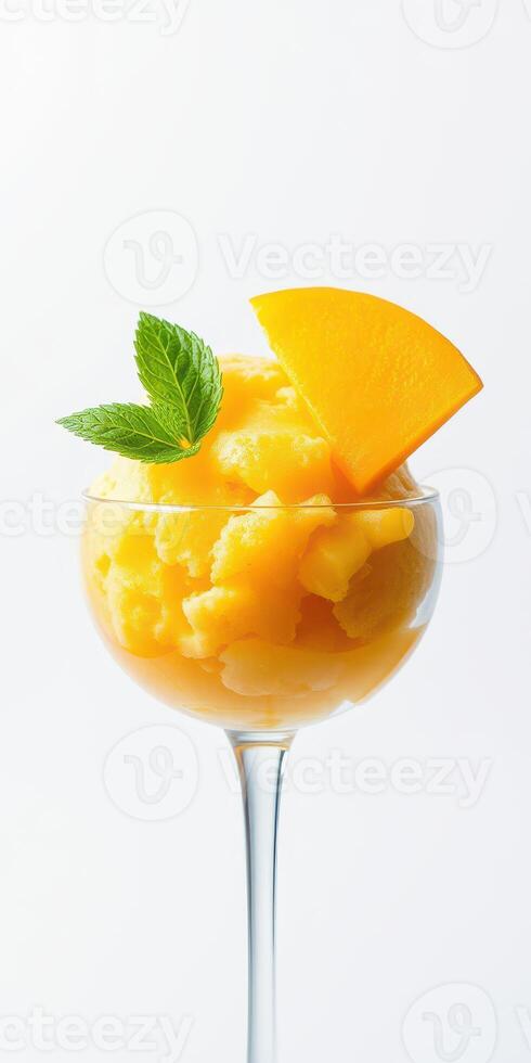 Refreshing mango sorbet served in a glass with mint leaves and a slice of fresh mango photo