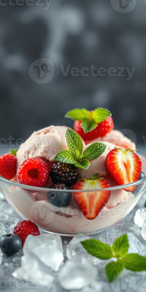 Delicious dessert featuring mixed berries and mint on a bed of creamy ice cream served in a clear bowl photo