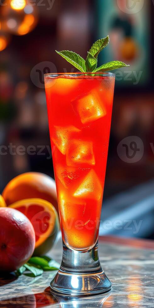 Refreshing red cocktail garnished with mint leaves in a tall glass surrounded by citrus fruits photo