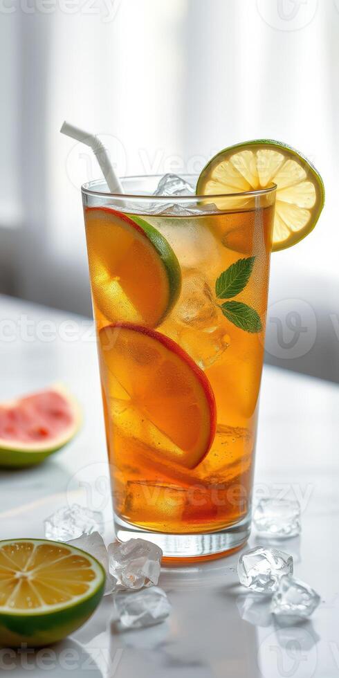 Refreshing iced tea garnished with citrus slices and mint on a marble surface during a sunny day photo