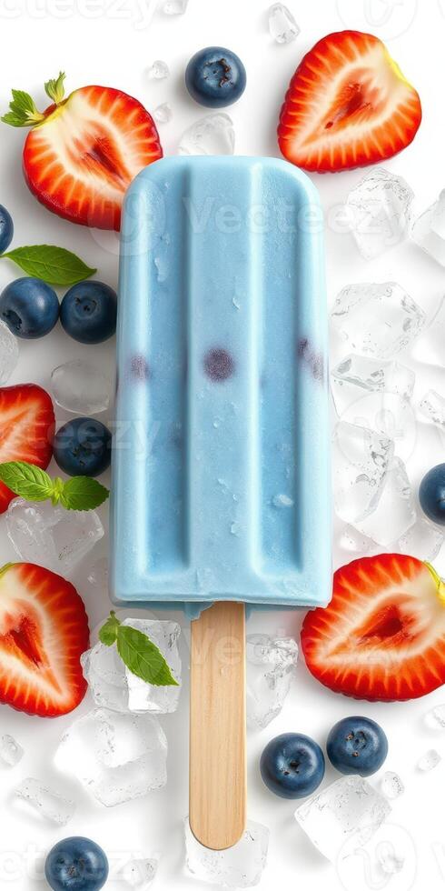 Colorful ice pop surrounded by fresh strawberries, blueberries, and ice cubes on a white background photo