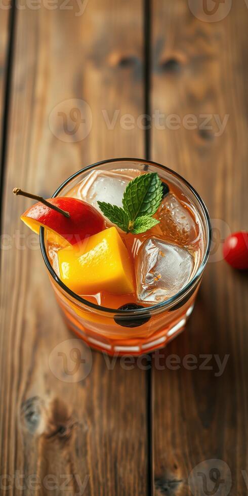 Refreshing tropical drink with mango and mint served over ice on a wooden table photo