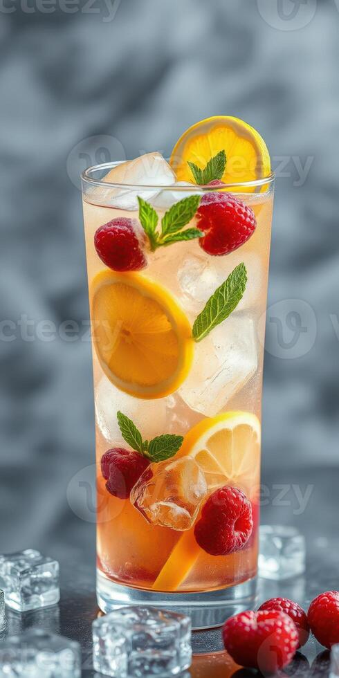 Refreshing summer drink with raspberries, lemons, and mint served over ice in a tall glass photo