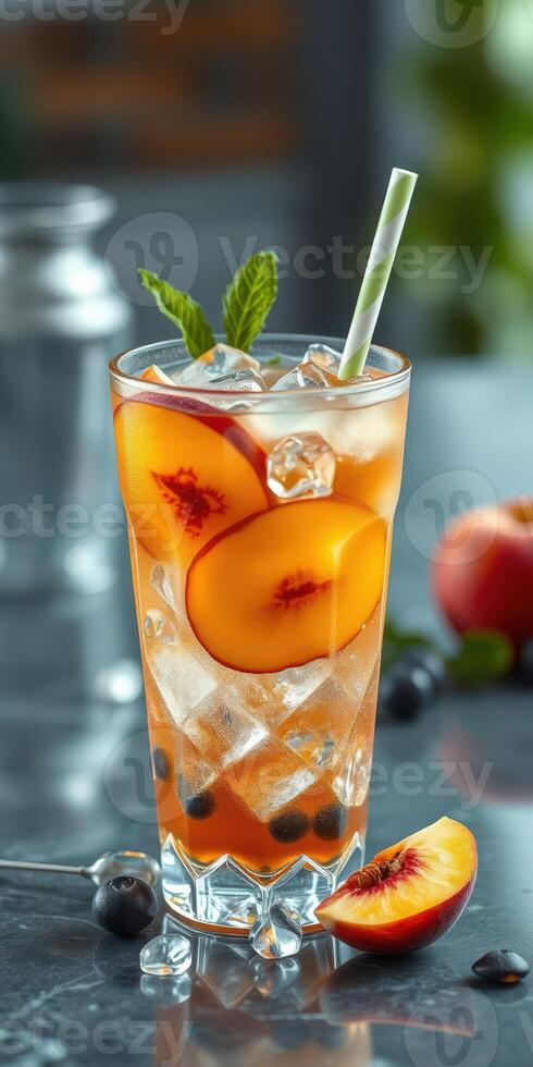Refreshing peach beverage with ice served in a glass with mint leaves on a stylish dining table photo