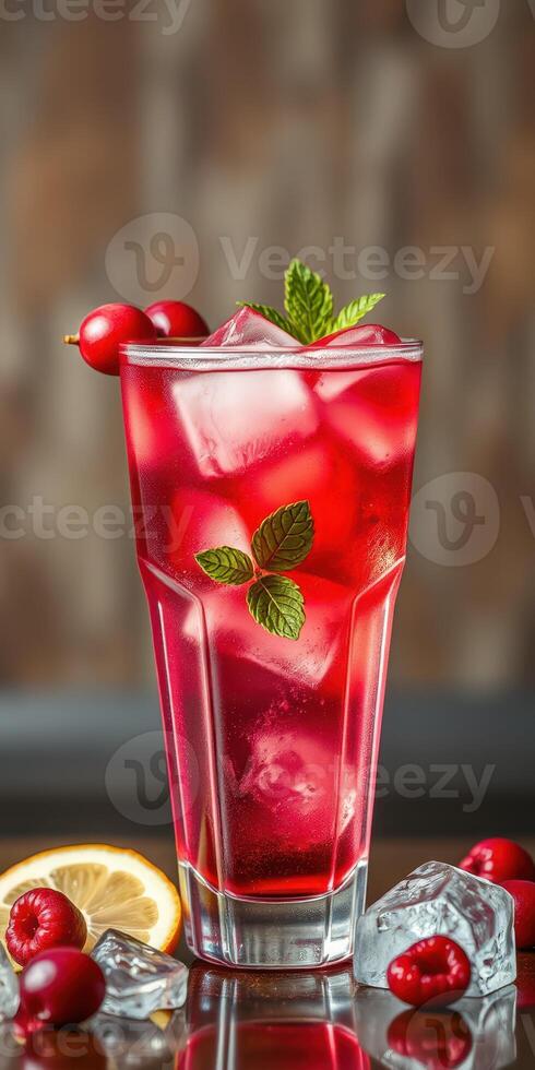 Refreshing red beverage garnished with mint and fruit served on a wooden table photo