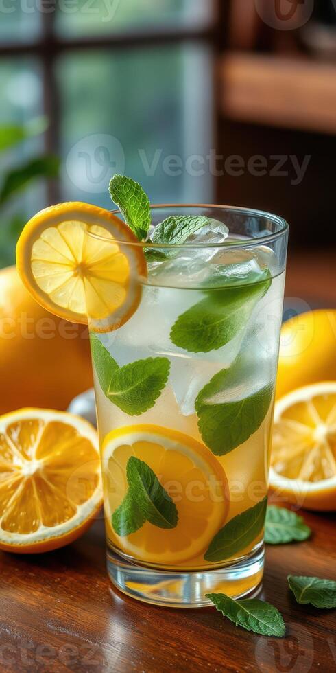 Refreshing lemonade with mint leaves and lemon slices on a wooden table during a sunny afternoon photo