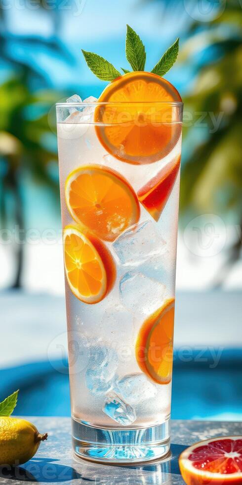 Refreshing citrus drink served in a tall glass with ice and garnished with mint on a sunny beachside photo