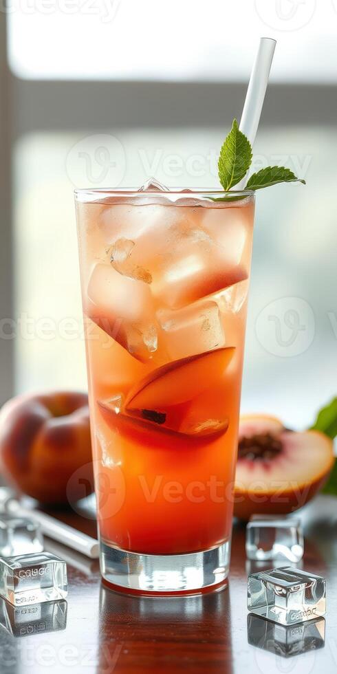 Refreshing peach iced tea with mint garnished and ice cubes on a wooden table in bright setting photo