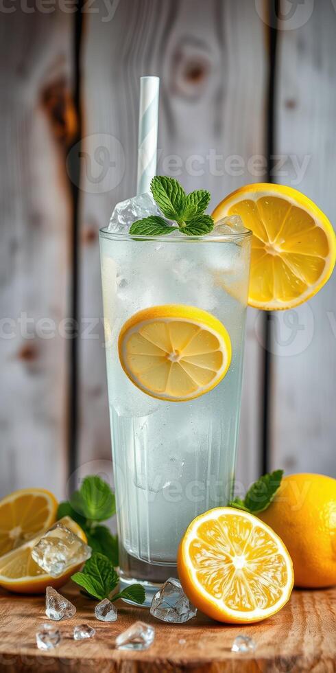 Refreshing lemonade with mint and ice served in a tall glass on a wooden table photo