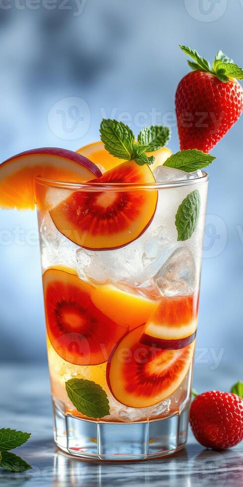 Refreshing fruit cocktail with peaches and strawberries garnished with mint leaves at a summer gathering photo