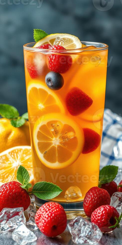 Refreshing fruit beverage garnished with raspberries, blueberries, and lemon slices in a tall glass photo