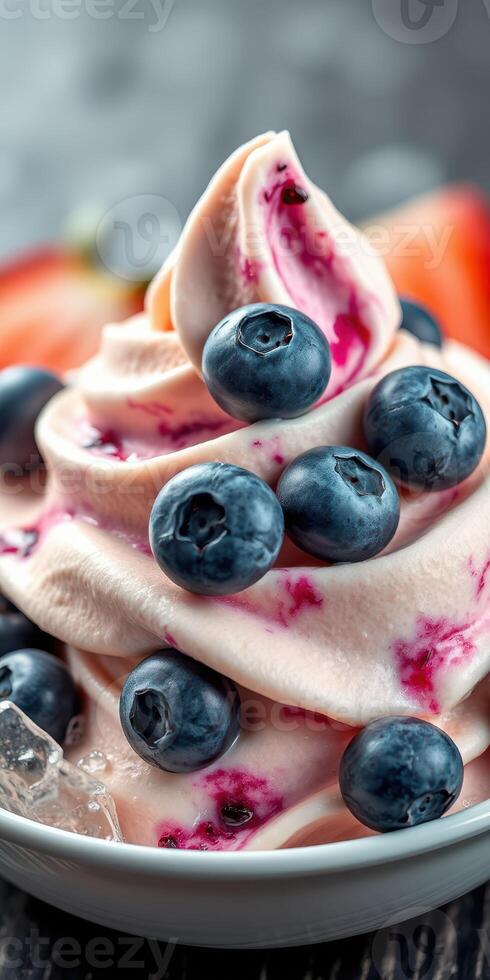Delicious frozen yogurt topped with fresh blueberries and vibrant fruit swirls served in a bowl photo