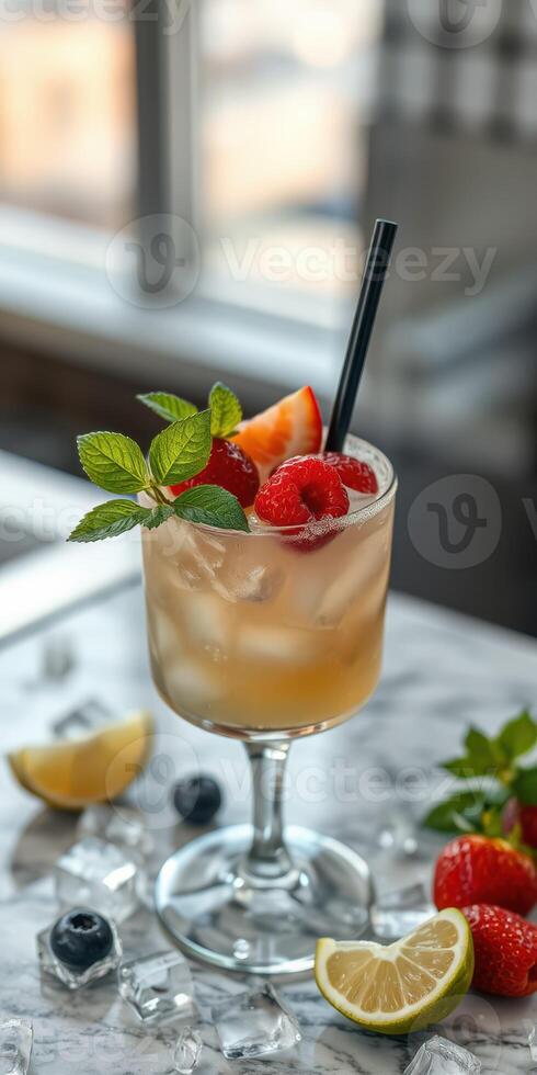 Refreshing fruit cocktail garnished with berries and mint placed on a marble table in a bright setting photo