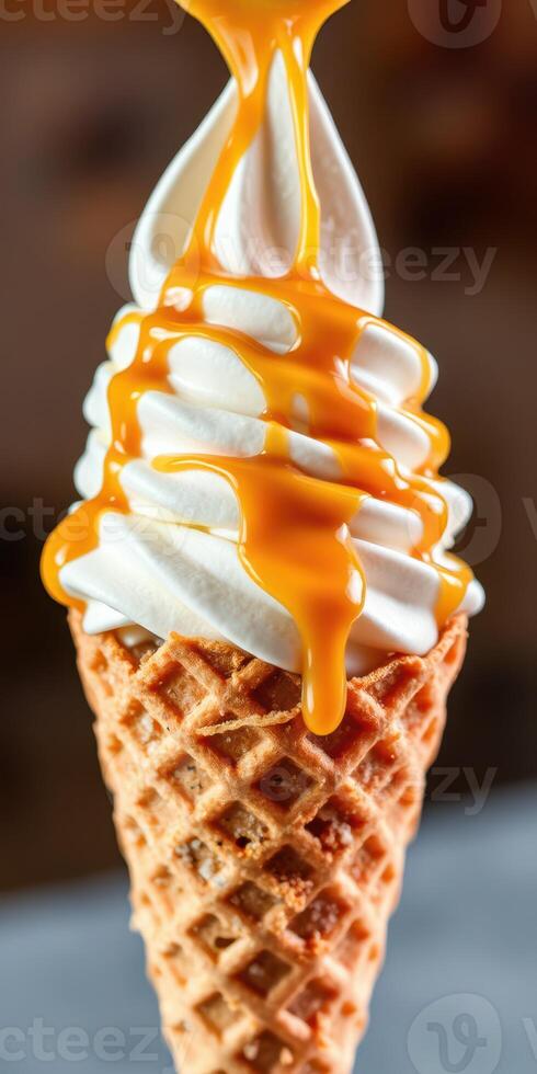Creamy vanilla ice cream with caramel drizzle served in a crispy cone photo