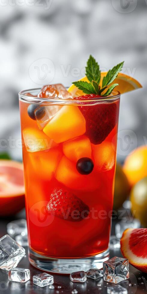 Refreshing fruit cocktail served in a chilled glass garnished with mint and lemon slice on a dark table photo