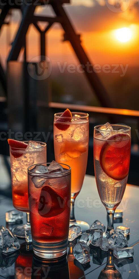 Colorful cocktails with fresh fruits served on a table during a sunset at a rooftop bar photo