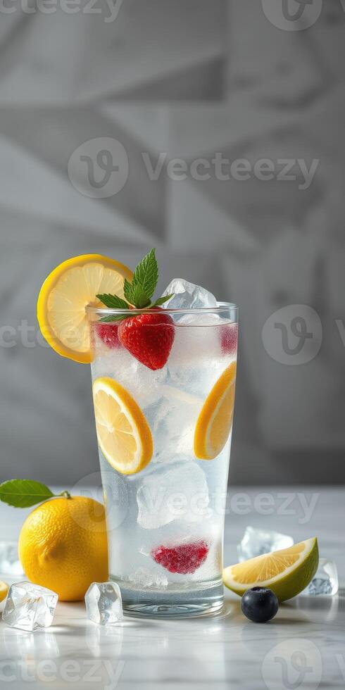 Refreshing lemonade with raspberries and mint on a marble table surrounded by lemons and ice cubes photo