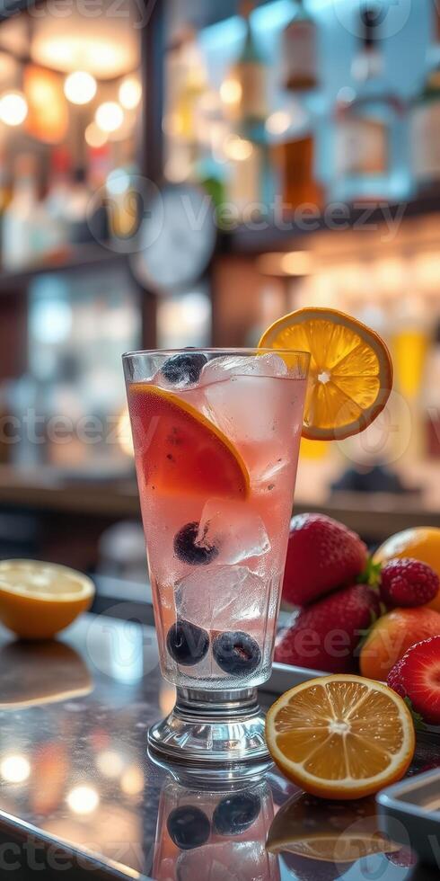 Refreshing fruity cocktail served in a glass with summer fruits on a bar counter photo
