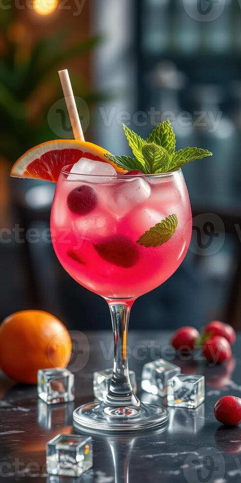 Refreshing tropical cocktail with fruits and mint served in a stylish glass on a marble table photo