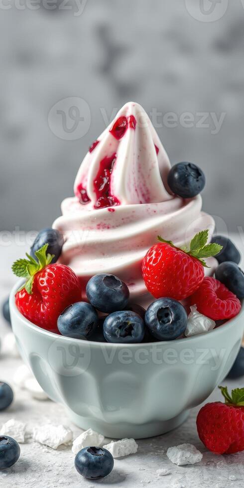 Delicious berry swirl soft serve topped with fresh strawberries and blueberries in a bowl photo