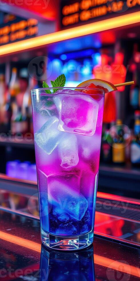 Colorful cocktail with ice served at a vibrant bar during the night photo