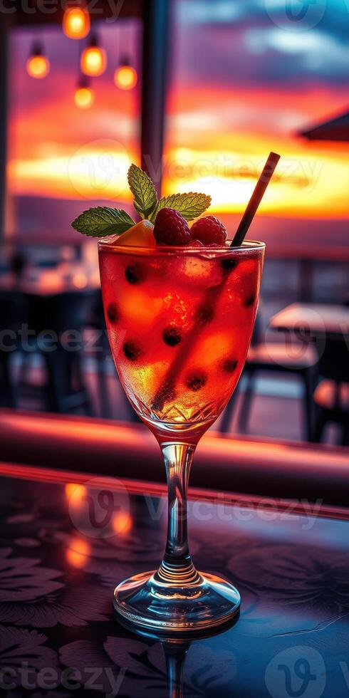 Sunset cocktail garnished with fruit and mint served in a stylish glass at a seaside bar photo
