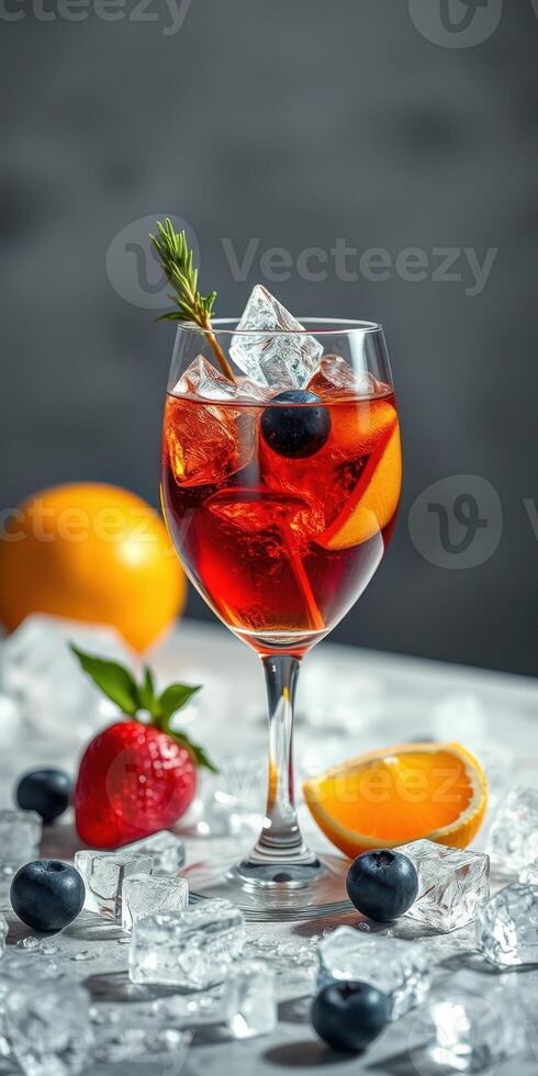Refreshing summer cocktail with ice, berries, and citrus fruits garnished elegantly in a clear glass photo
