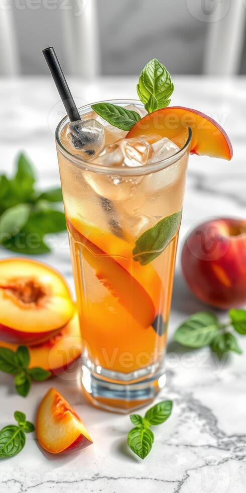 Refreshing peach iced tea garnished with mint leaves on a marble countertop during sunny afternoon photo