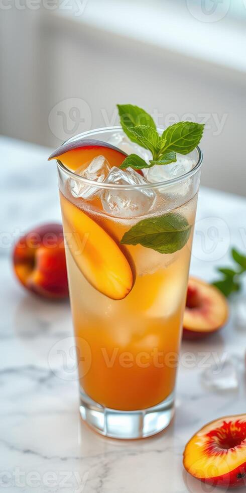 Refreshing summer drink with peach slices and mint leaves on a marble countertop photo