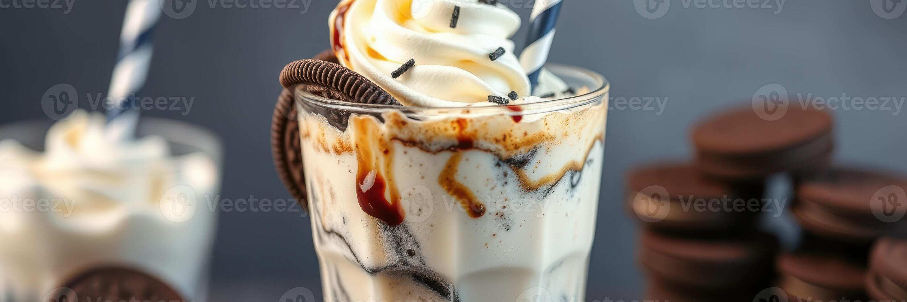 Indulgent vanilla milkshake topped with whipped cream and chocolate syrup served with cookies photo