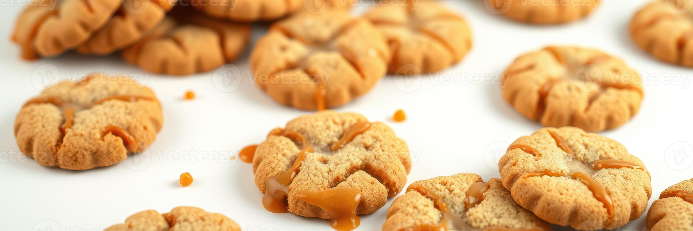 Freshly baked cookies laid out on a white surface with caramel drizzled on some, inviting a sweet treat experience photo