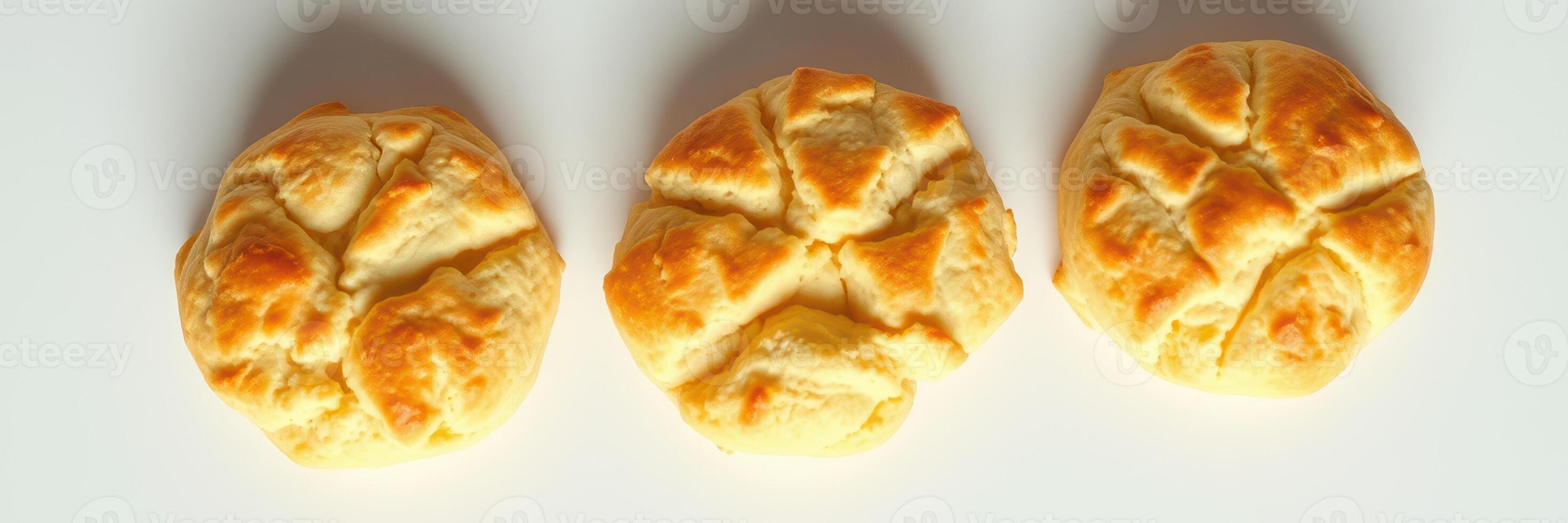 Freshly baked round bread rolls with a golden crust arranged on a white background photo