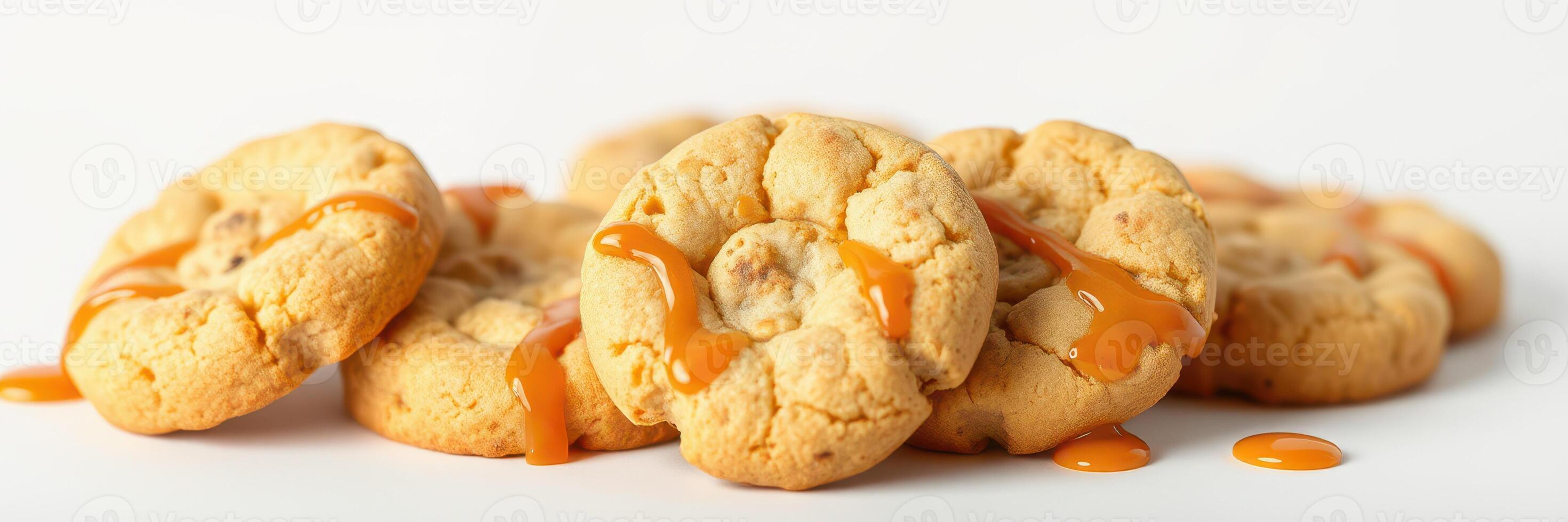 Freshly baked cookies drizzled with caramel placed on a clean white surface photo
