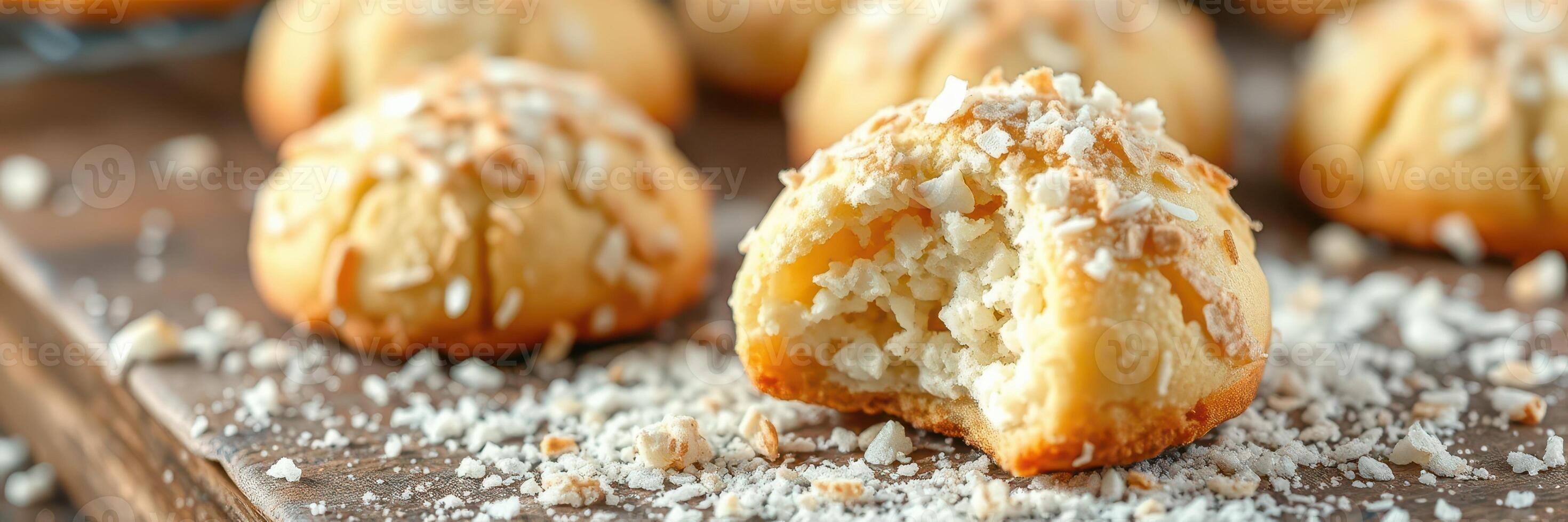 Delightful coconut cookies on a wooden tray showcasing bite marks and shredded coconut topping photo