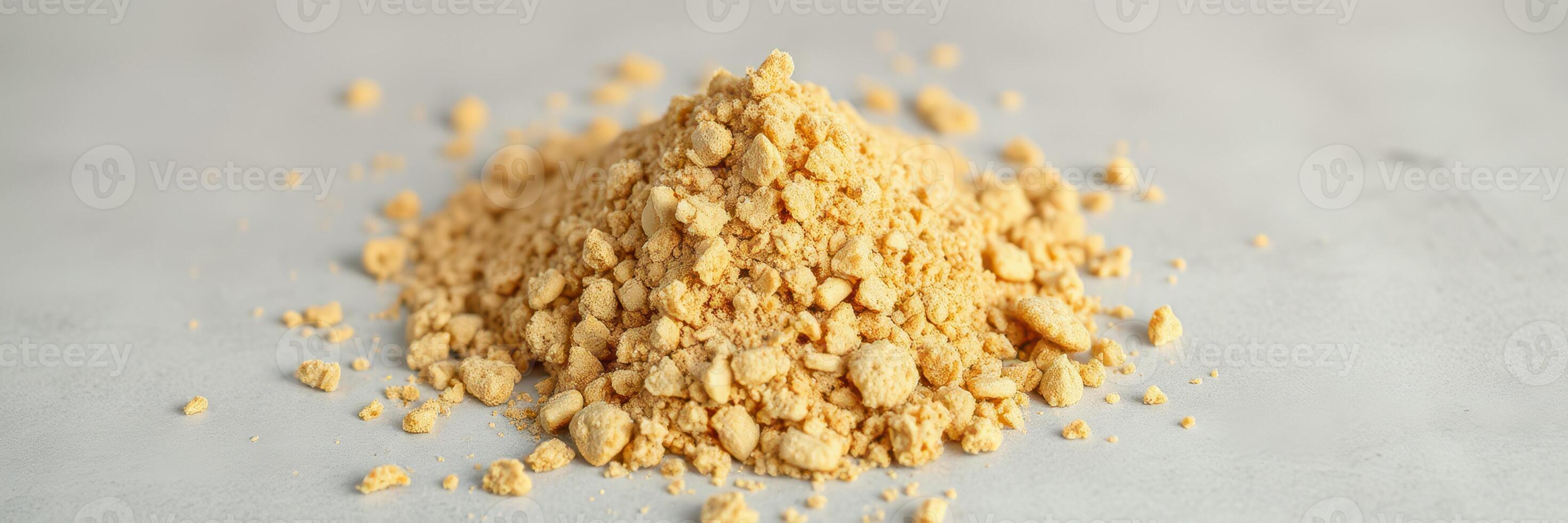 Ground ginger powder pile on a light surface ready for cooking and baking in culinary preparations photo