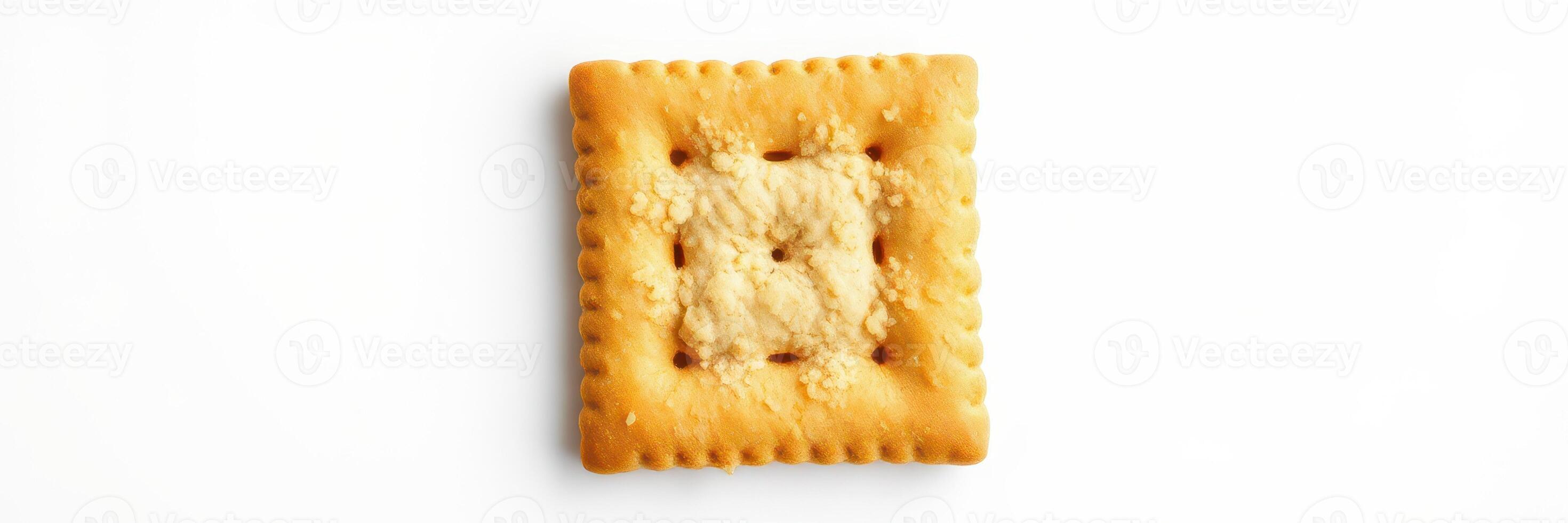 Classic square cracker with a golden color on a white background ideal for snacking or as a base for toppings photo