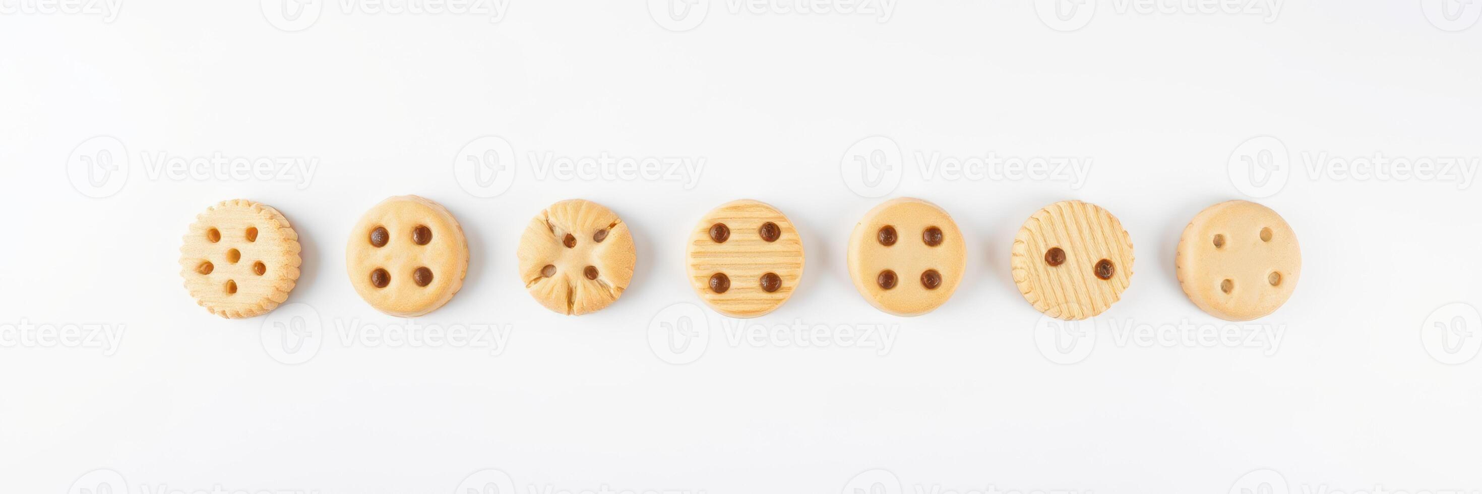 Unique wooden buttons arranged in a line on a white surface showcasing various designs and textures photo