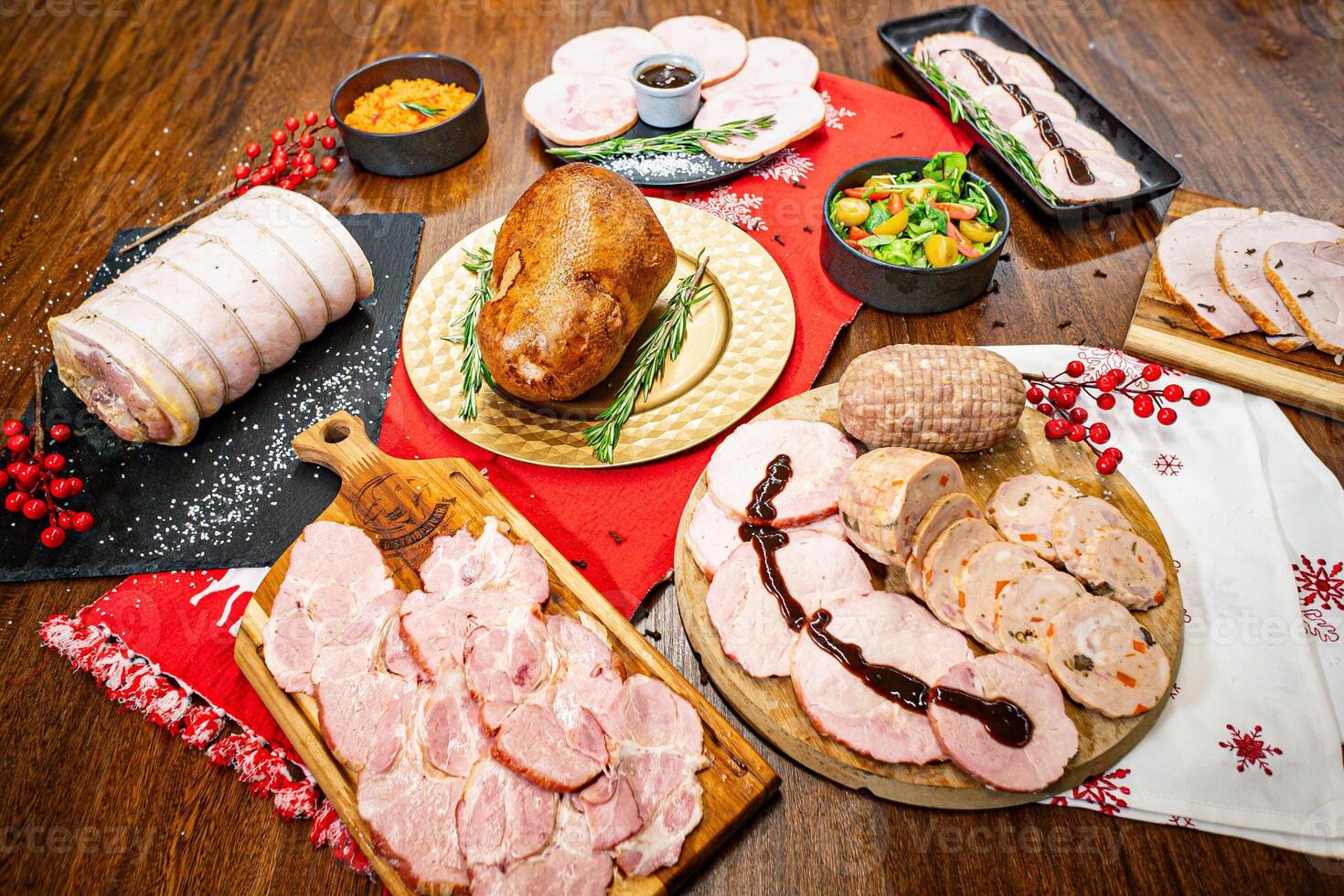 A table filled with Christmas products such as roasted turkey, pork leg, ham, and various holiday-season pickled accompaniments. photo