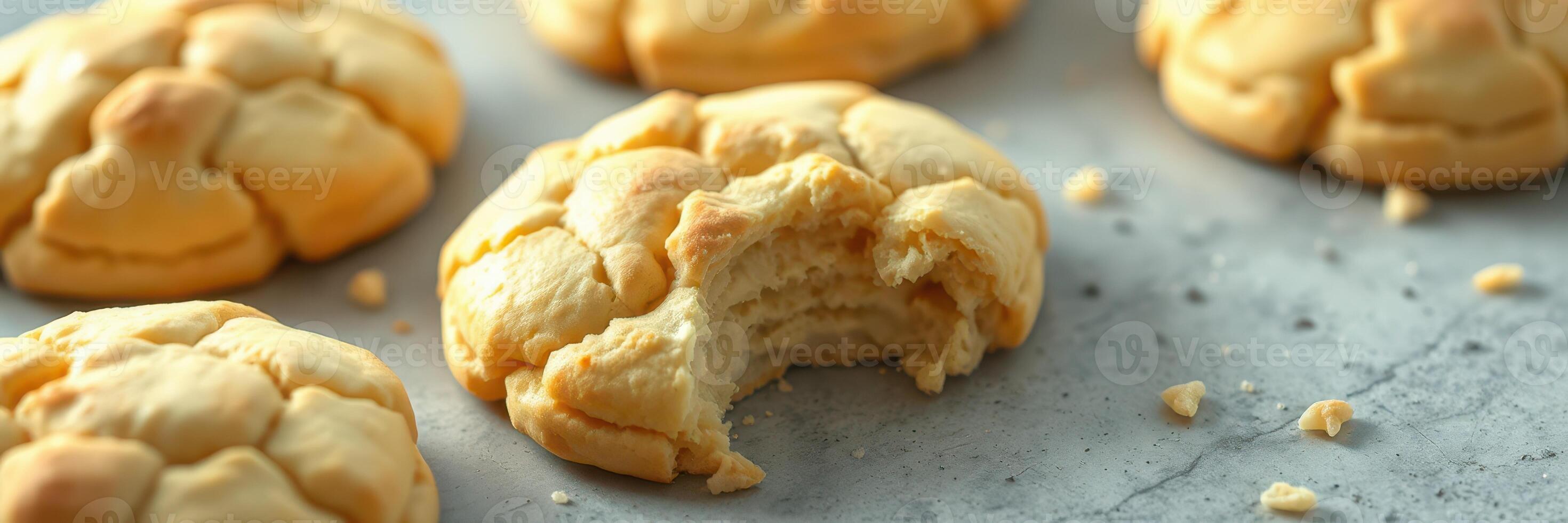 Freshly baked cookies on a marble countertop with a bite taken out of one photo