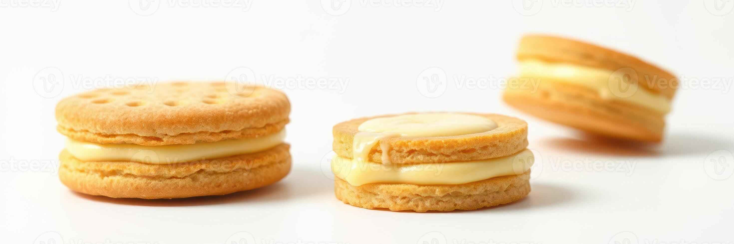Cream-filled cookies arranged on a white surface with one cookie slightly leaning photo