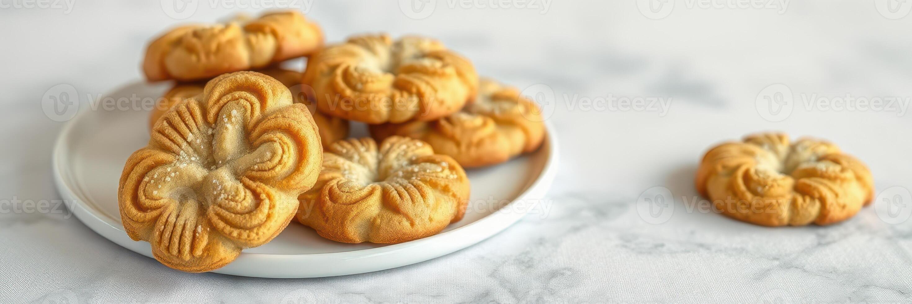 Freshly baked floral cookies arranged on a plate with a marble background showcasing their intricate design photo