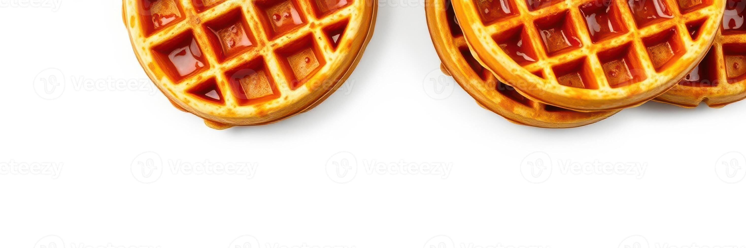 Deliciously golden waffles topped with syrup arranged on a white background ready for breakfast enjoyment photo