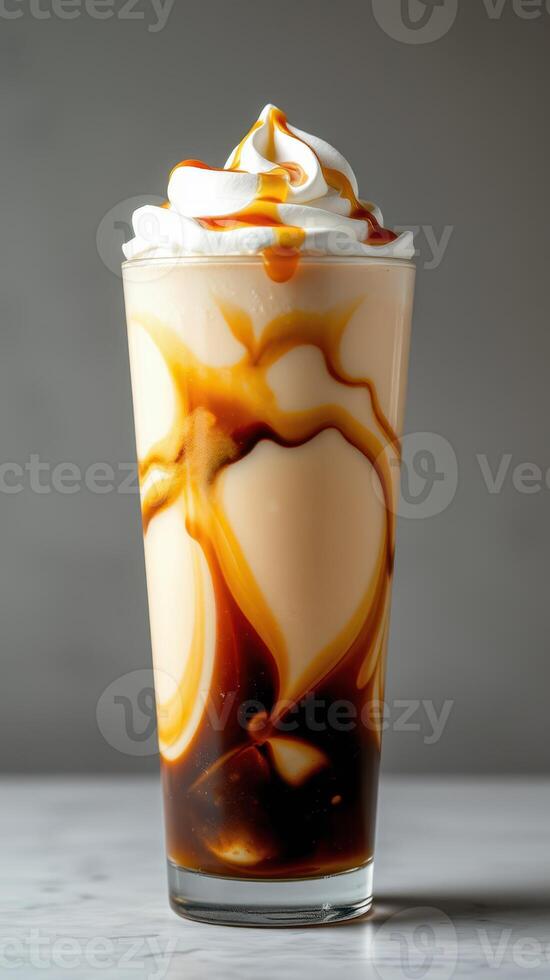 Delicious layered dessert drink topped with whipped cream and caramel sauce photo