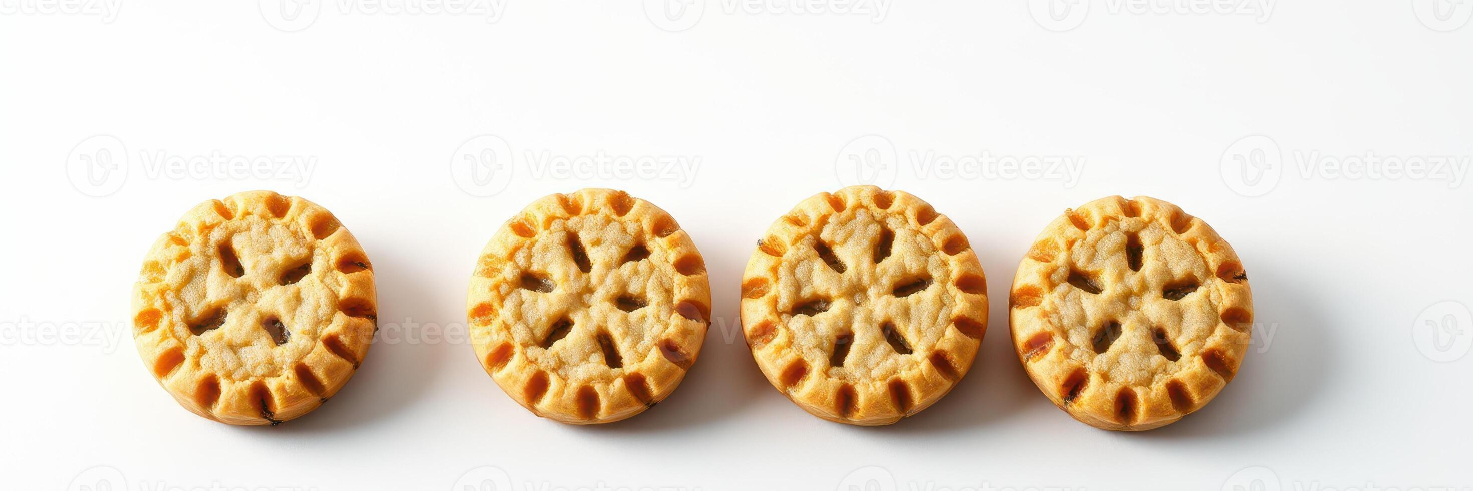 Delicious mini cookies arranged in a row on a white surface, showcasing their intricate design and golden color photo