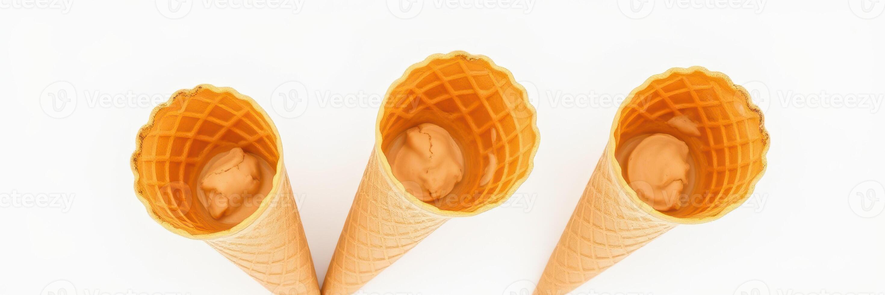 Three empty ice cream cones waiting to be filled on a plain white background photo