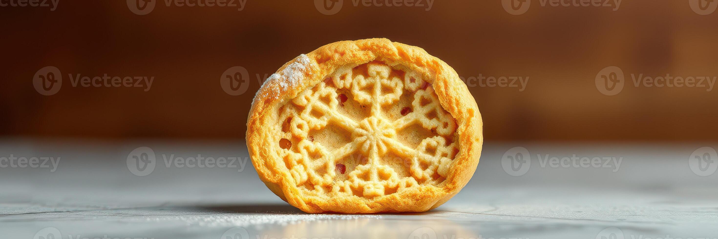 Delicate cookie with intricate design displayed on a marble surface in warm light photo