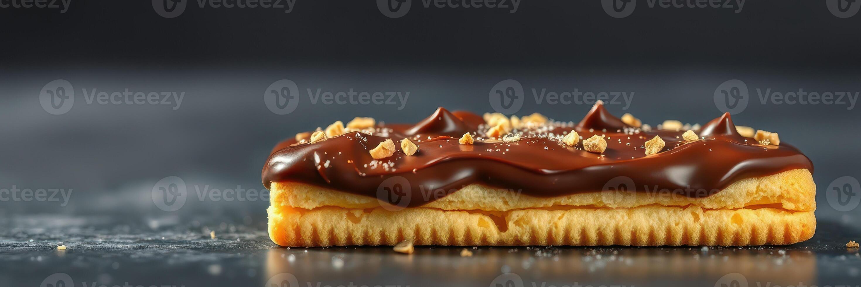 Delicious chocolate-covered pastry topped with crushed nuts on a dark background photo