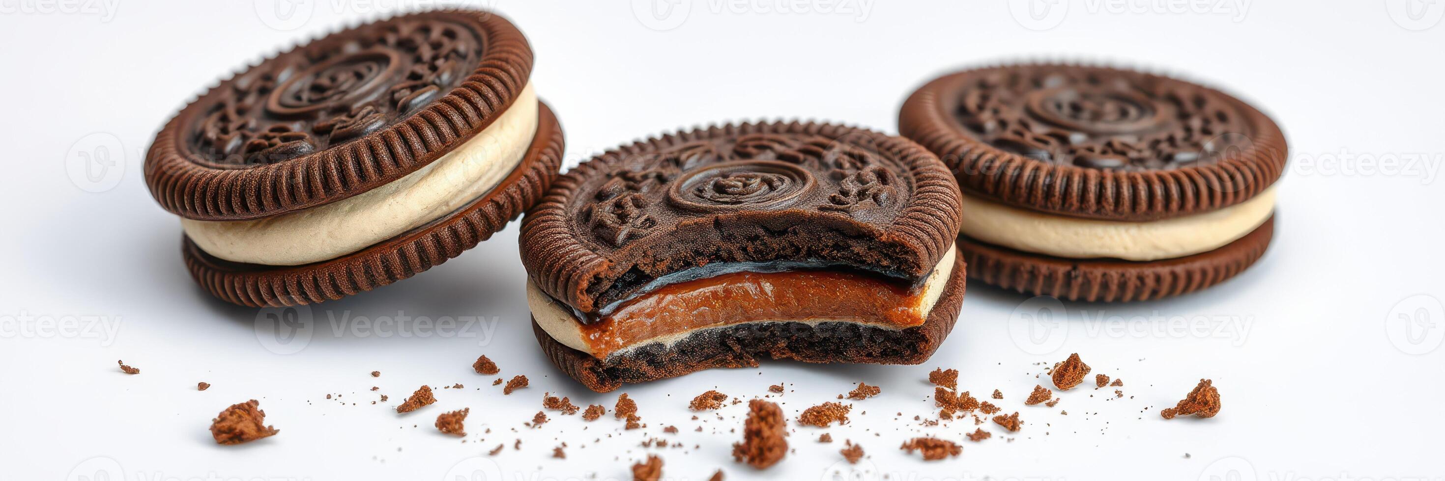 Chocolate sandwich cookies with creamy filling and caramel center displayed on a clean surface photo